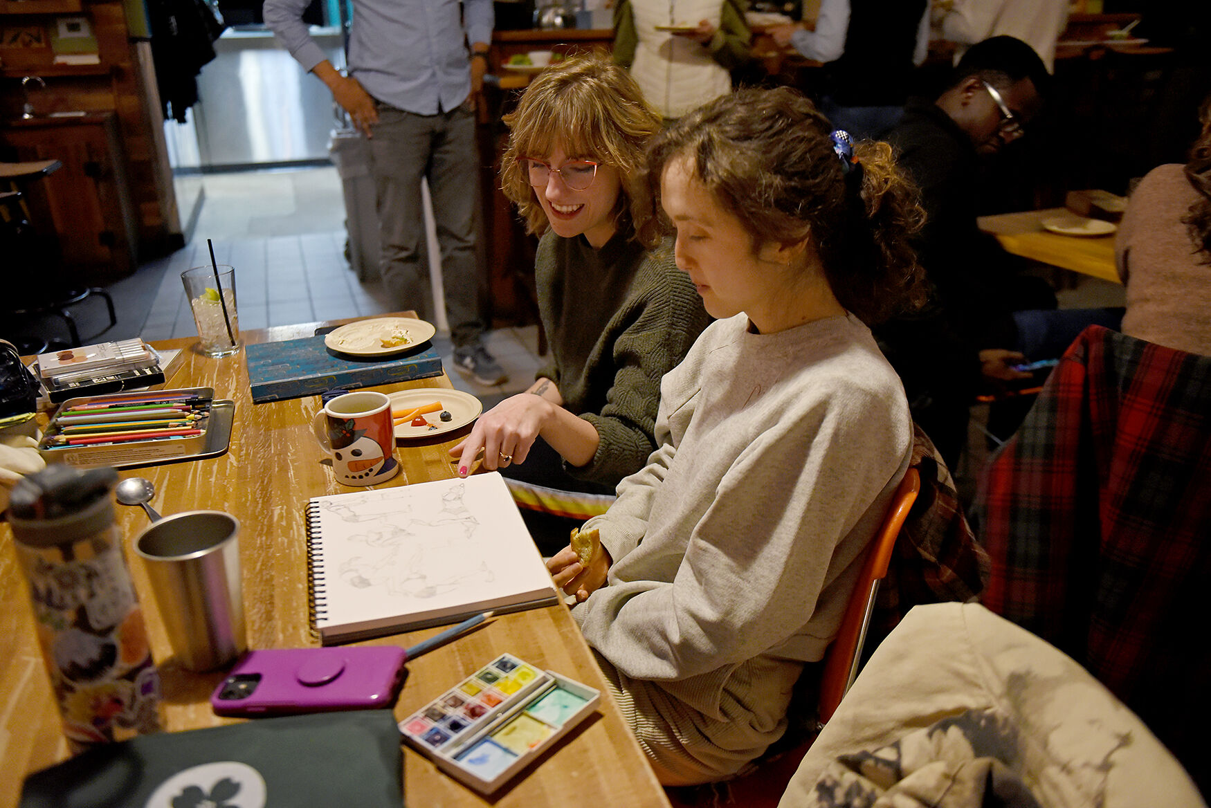 Claire Johnson, front, and Adrienne Luther talk about a drawing